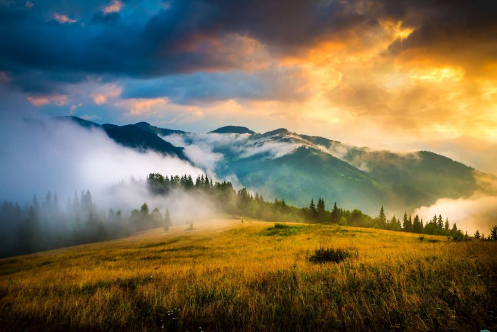 Berglandschap met mist bij zonsondergang