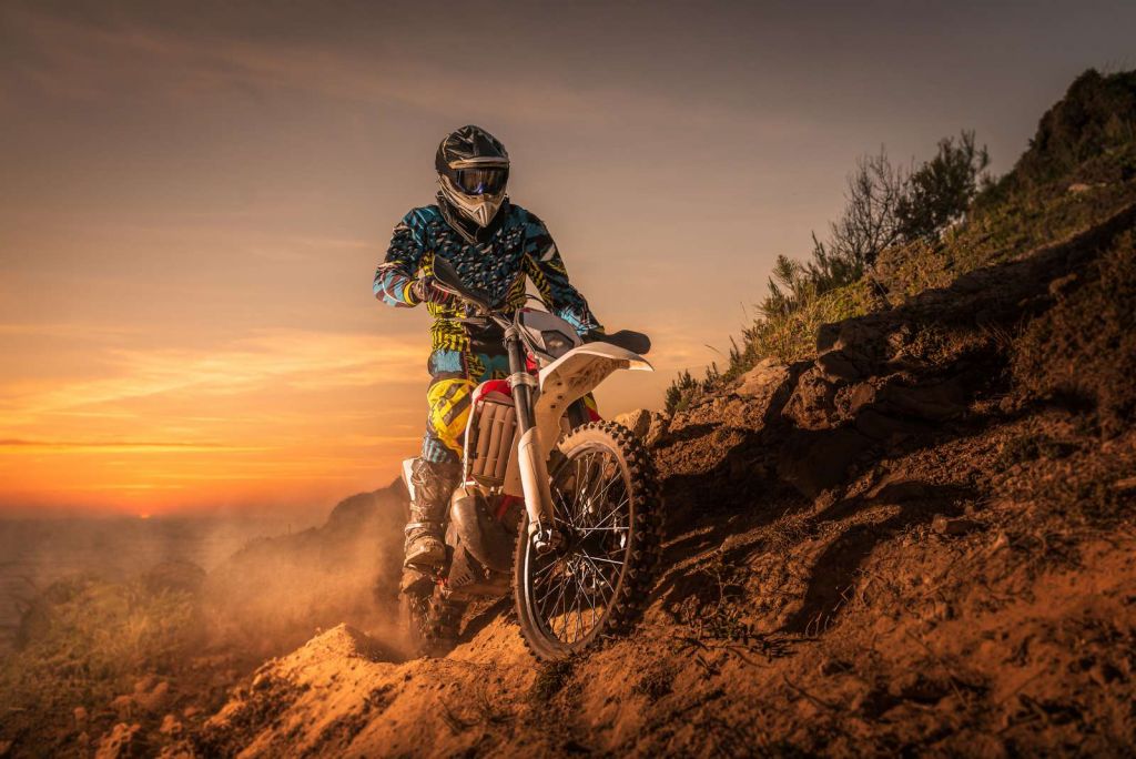 Crossmotor bij zonsondergang