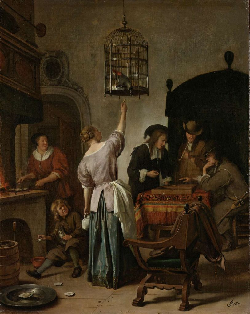 Interieur met een vrouw die een papegaai voert