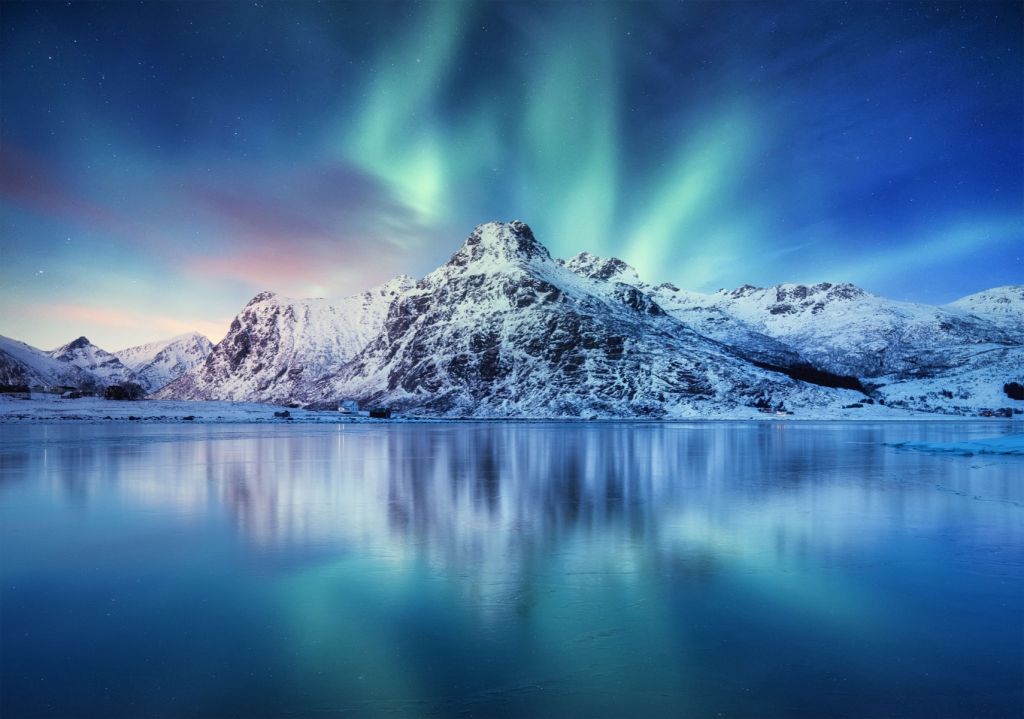 Northern lights over a frozen ocean and mountains