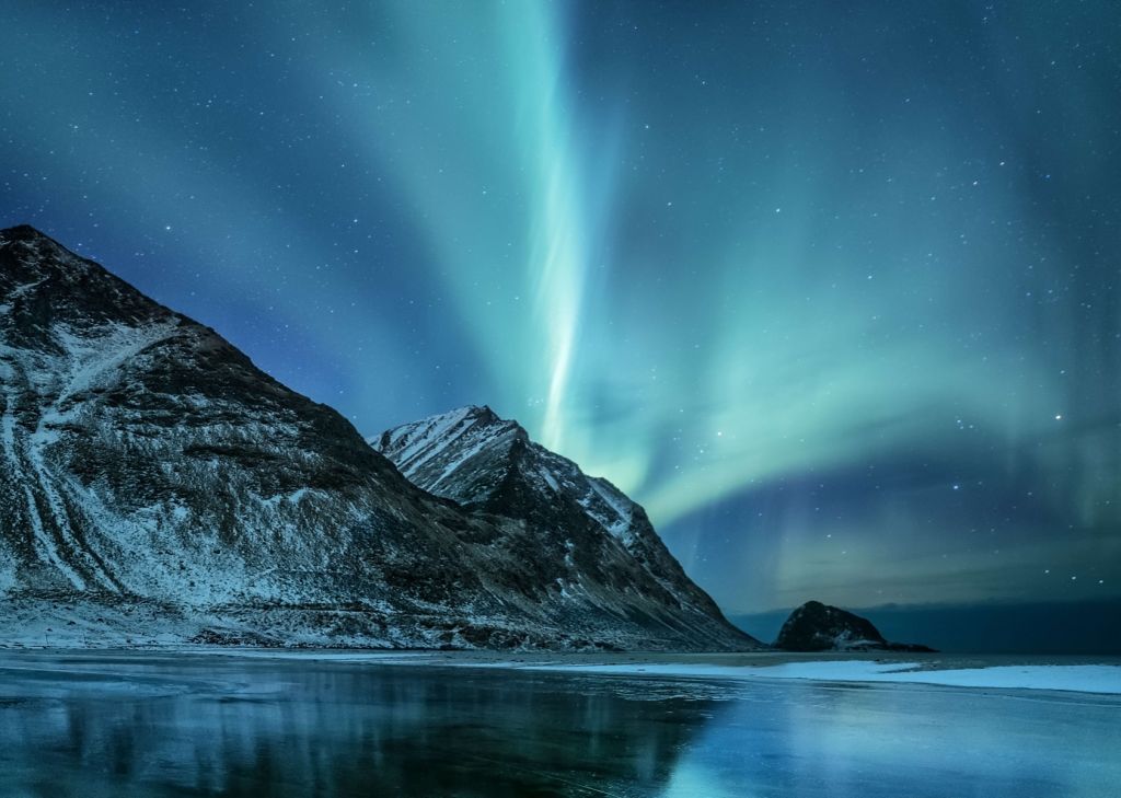 Green northern lights above the mountains