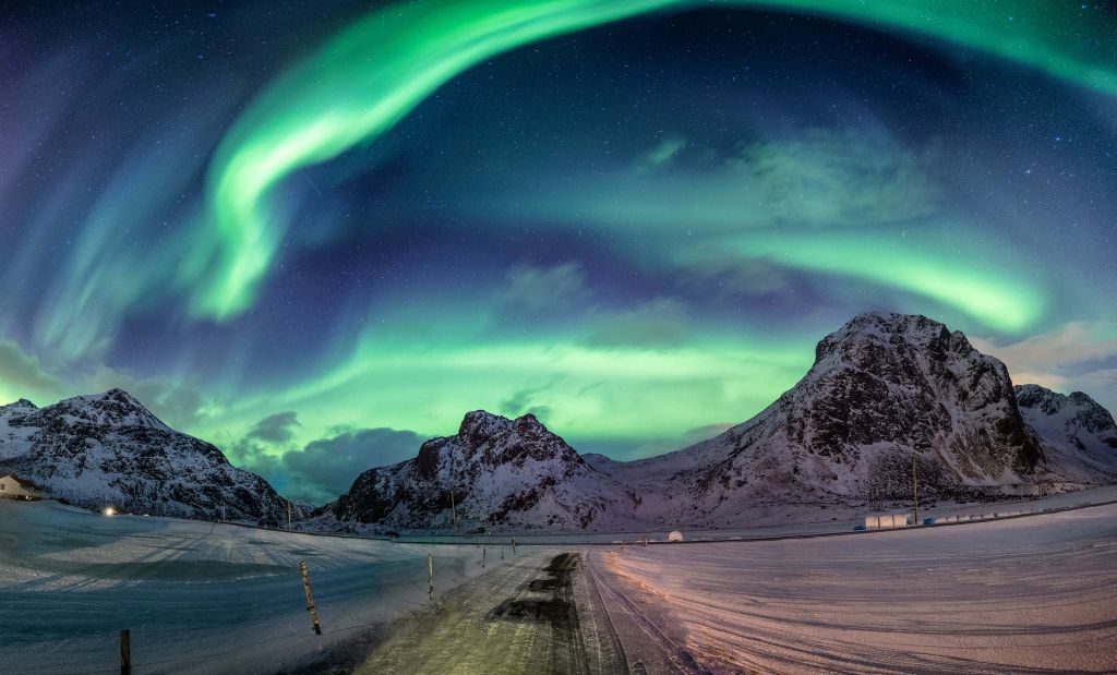 Northern lights above snowy mountains