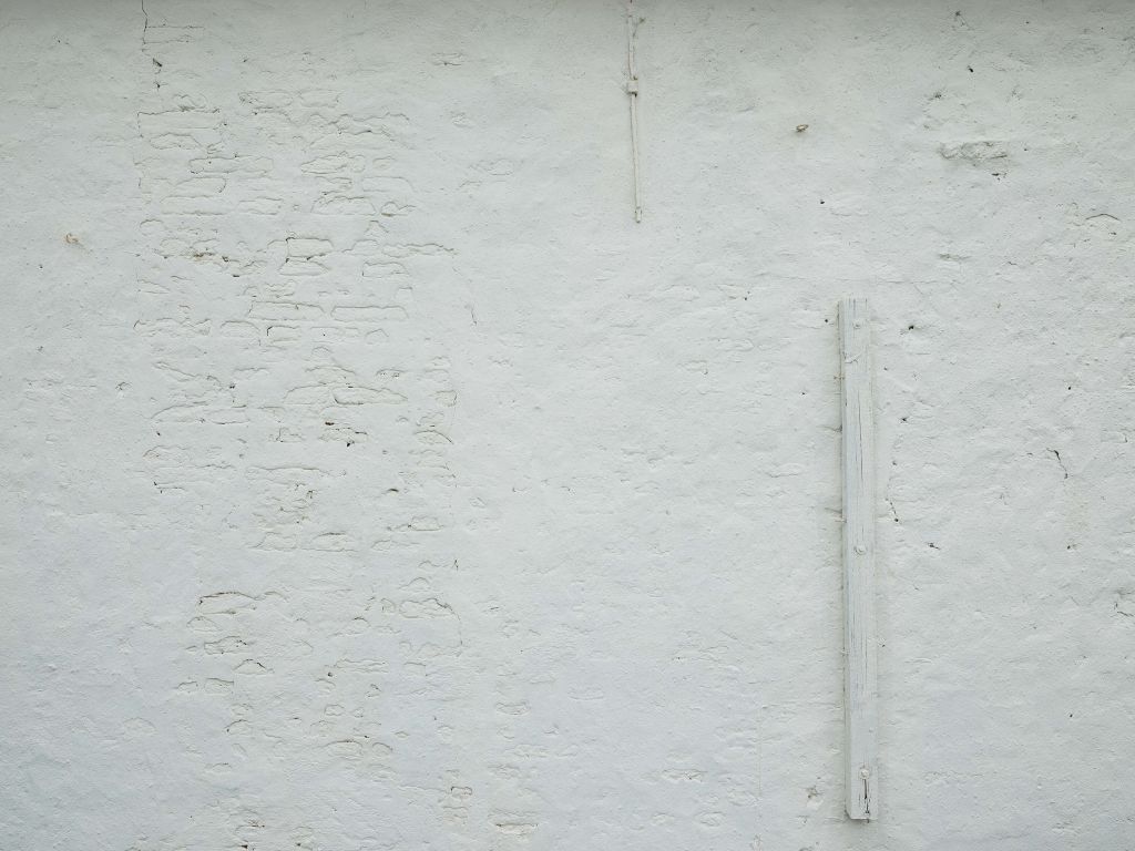 Wall with white stucco and beam