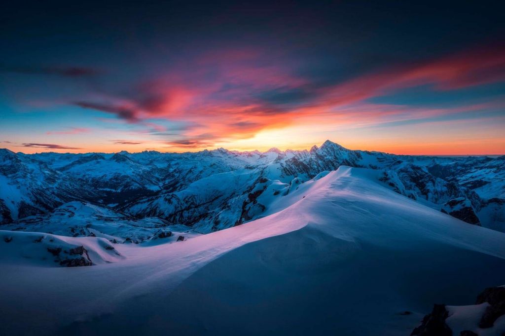 Snow-capped peaks at fiery dawn
