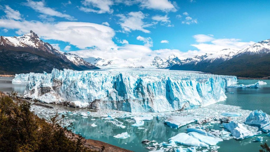 Ice wall by turquoise glacier lake