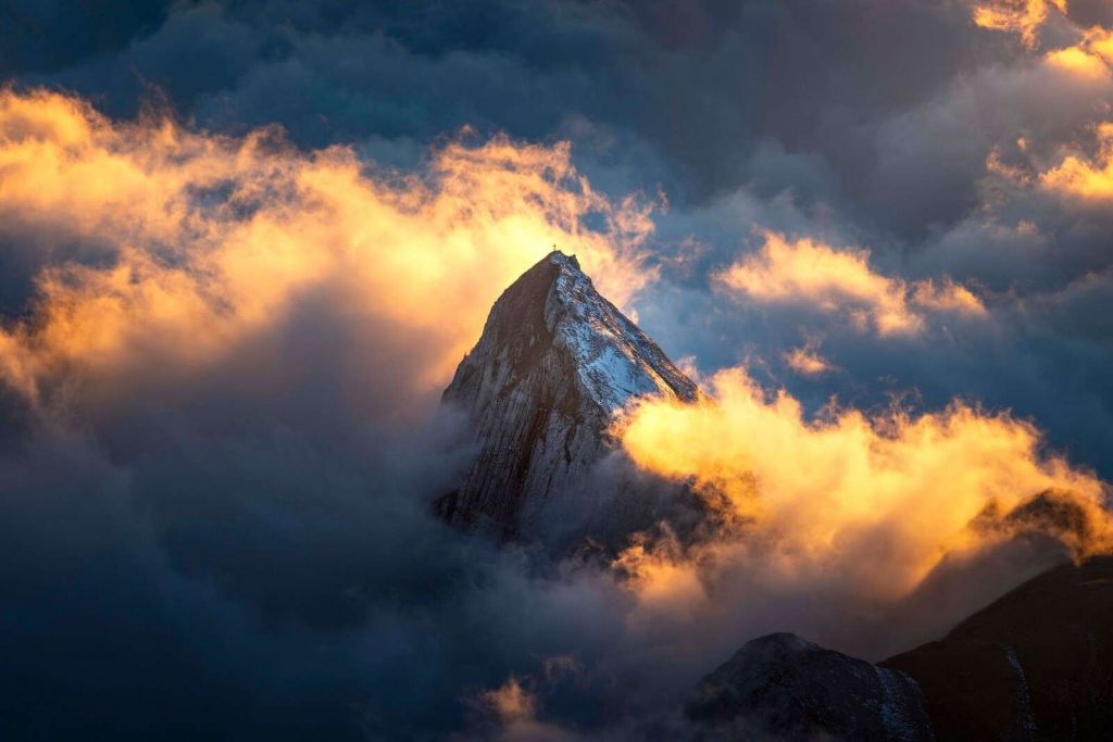 Mountain peak in fiery sea of clouds