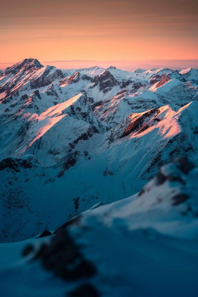 Snowy mountains against pink morning sky