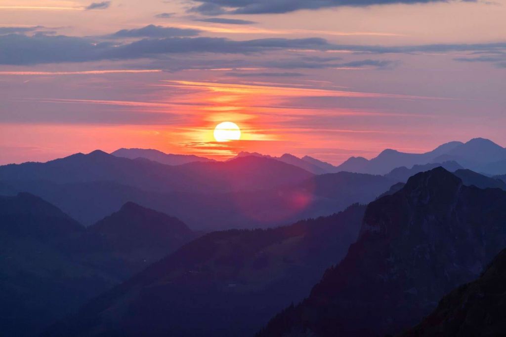 Sunset above purple mountain layers