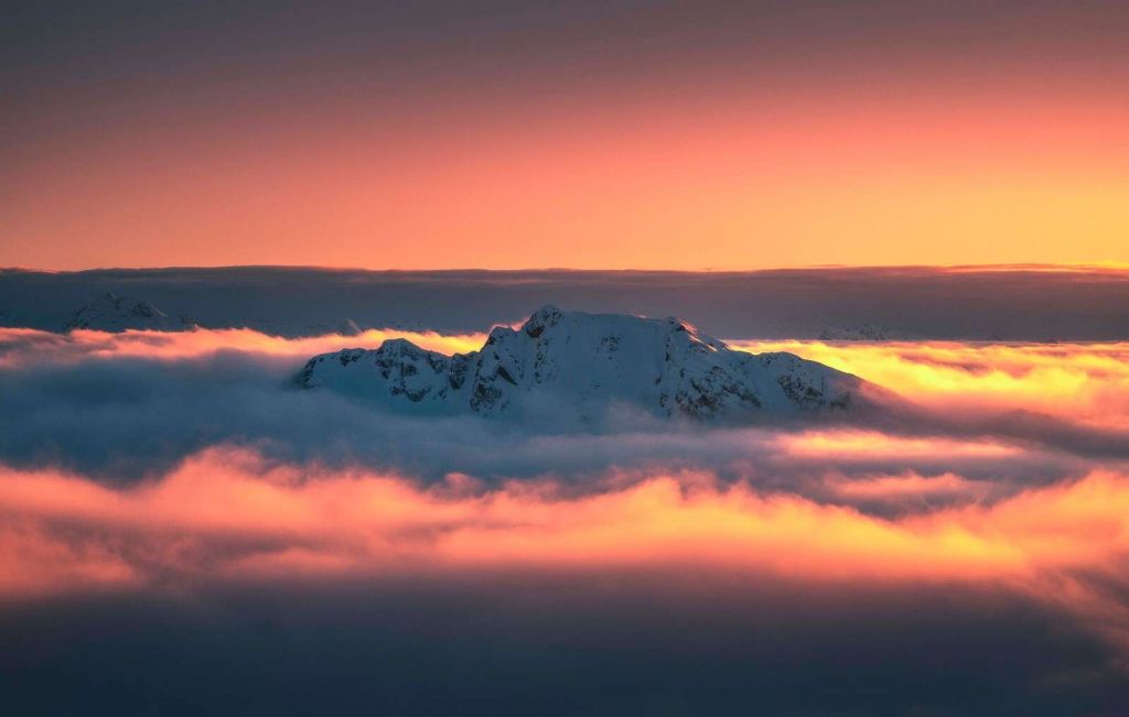 Snow-capped mountain peak in a sea of clouds