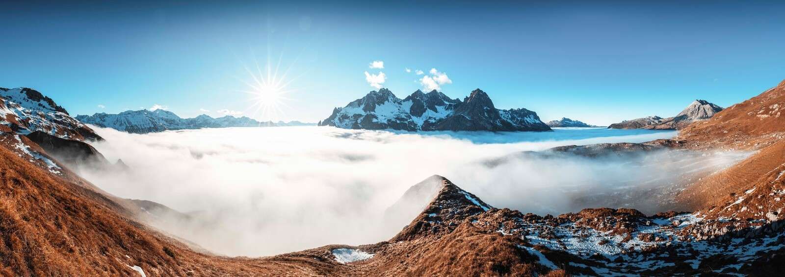 Sun-drenched mountain valley with a sea of clouds