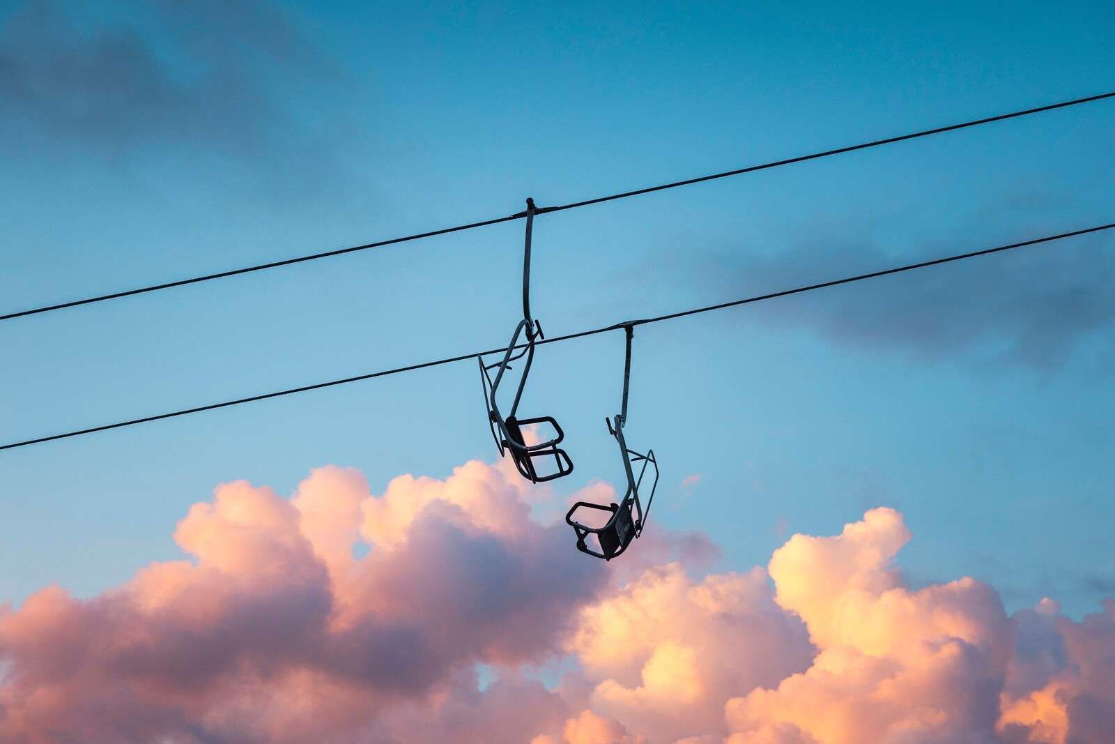 Chairlift above pink evening clouds