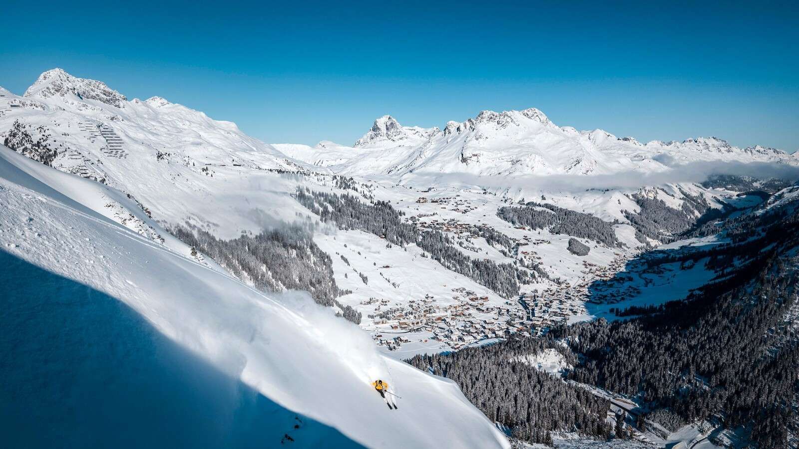 Descent above alpine village in snow.