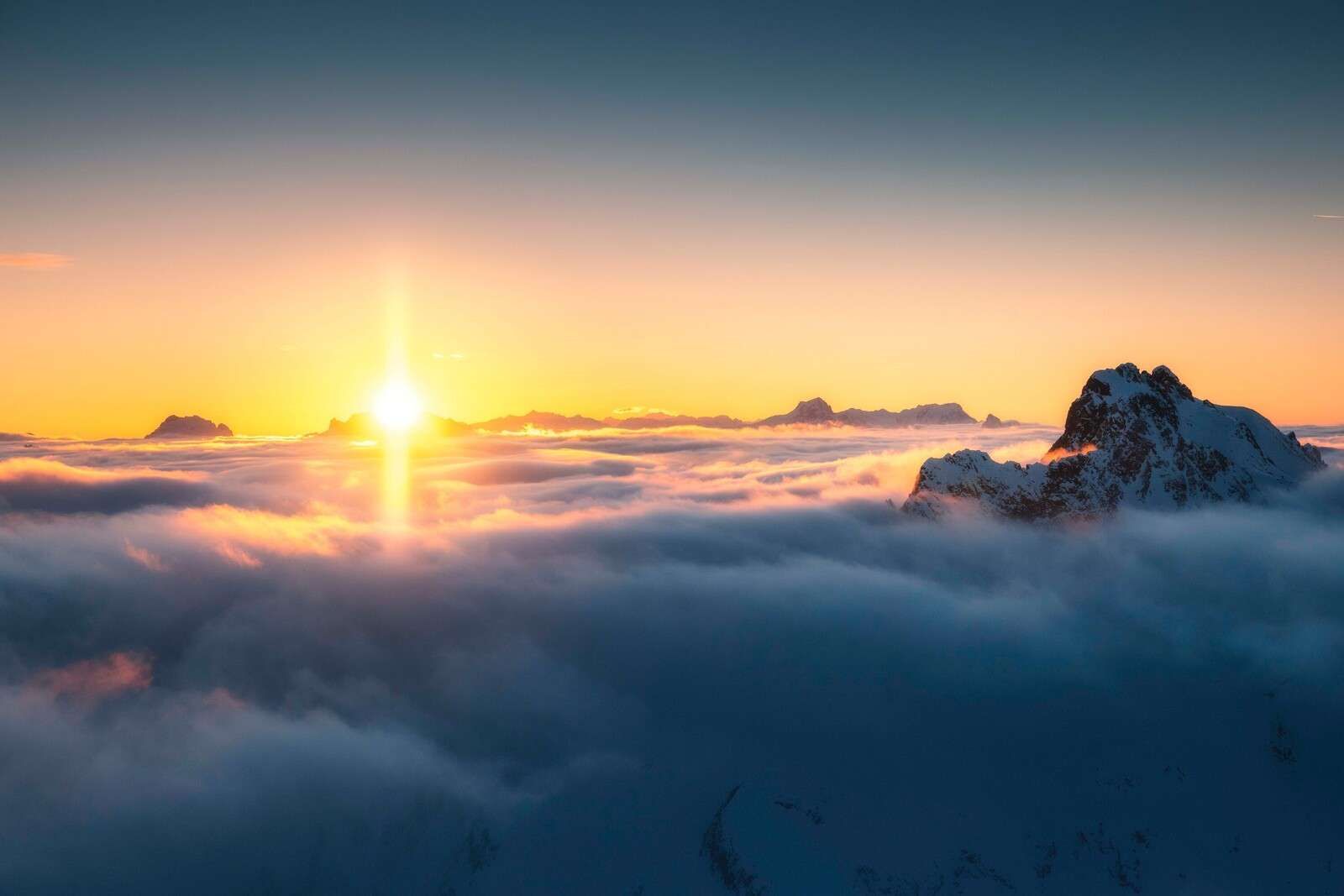 Sunrise above sea of clouds and mountain peaks