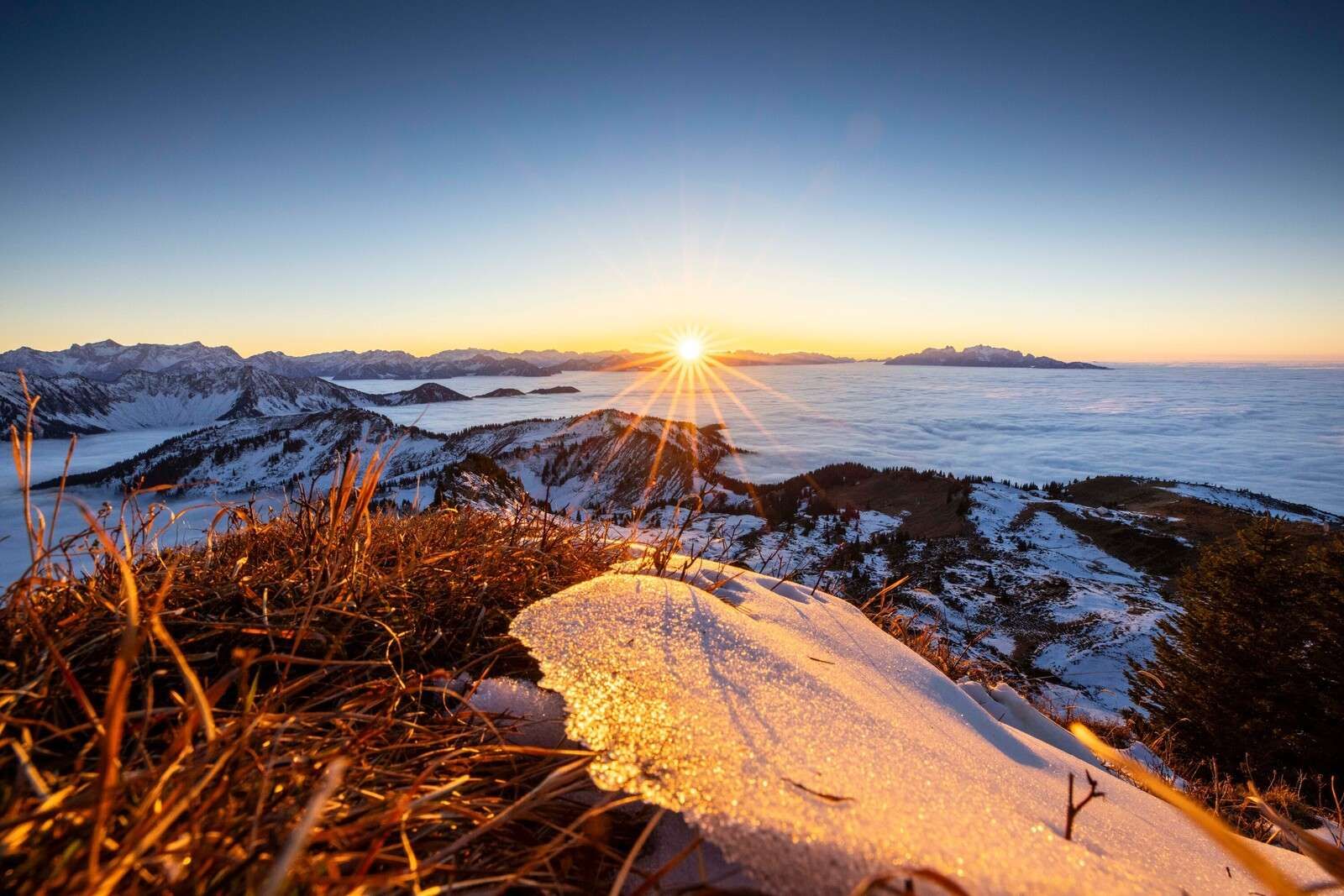 Sunrise above wintry mountain meadow