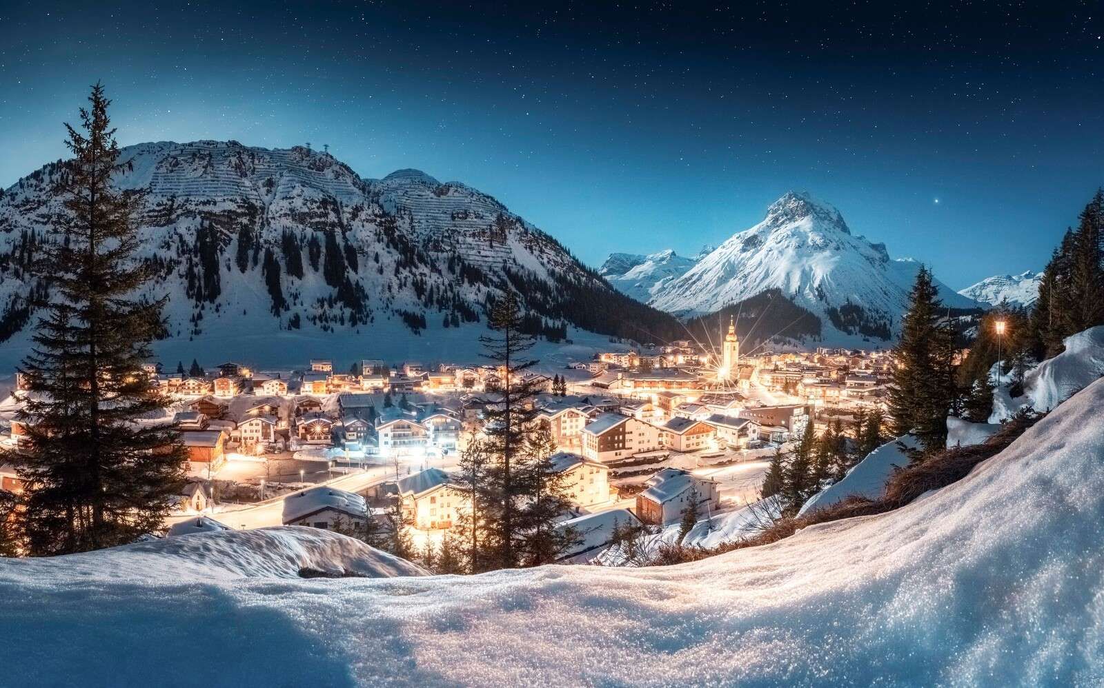 Sparkling alpine village under starry sky