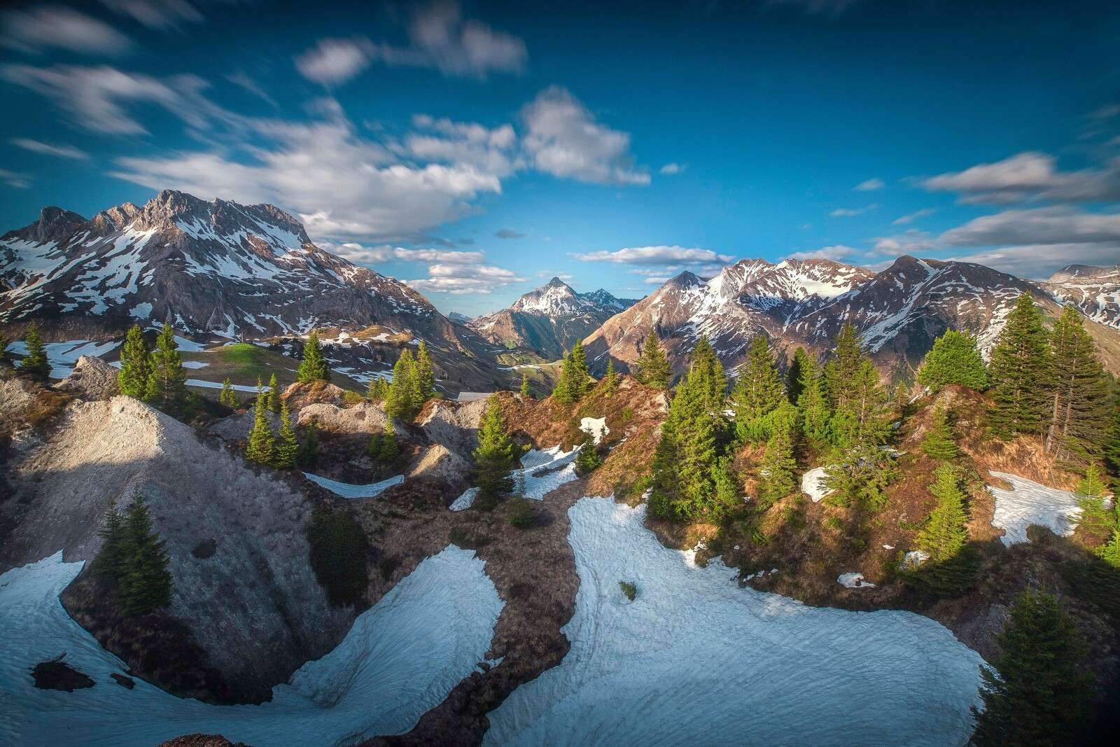 Lens flare over snow-covered mountain forest