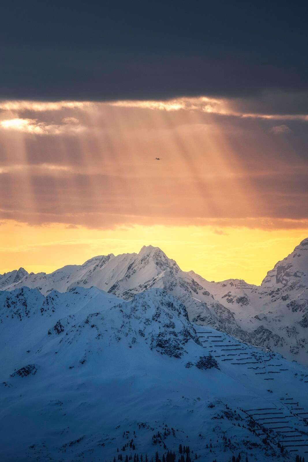 Sunbeams above snow-capped mountain peaks