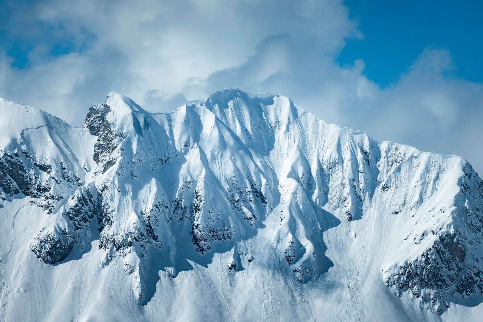 Steep snow-capped peaks under winter sun