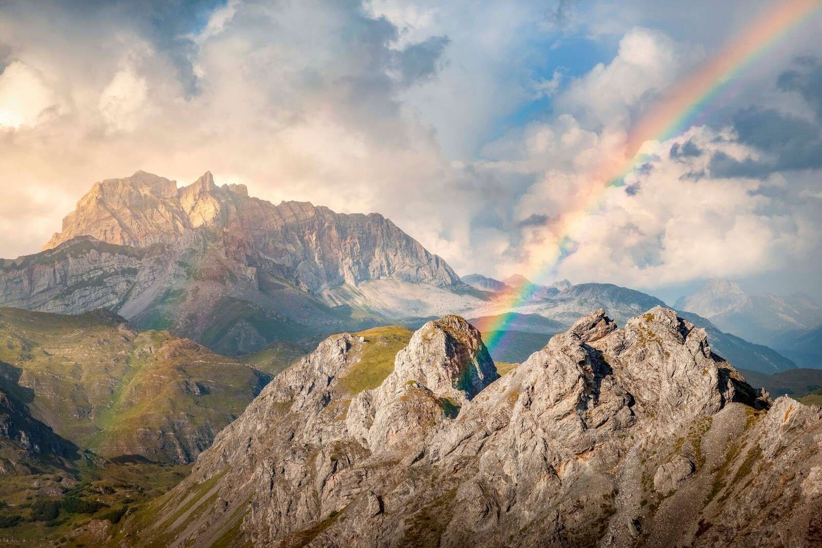 Rainbow light over rugged mountains