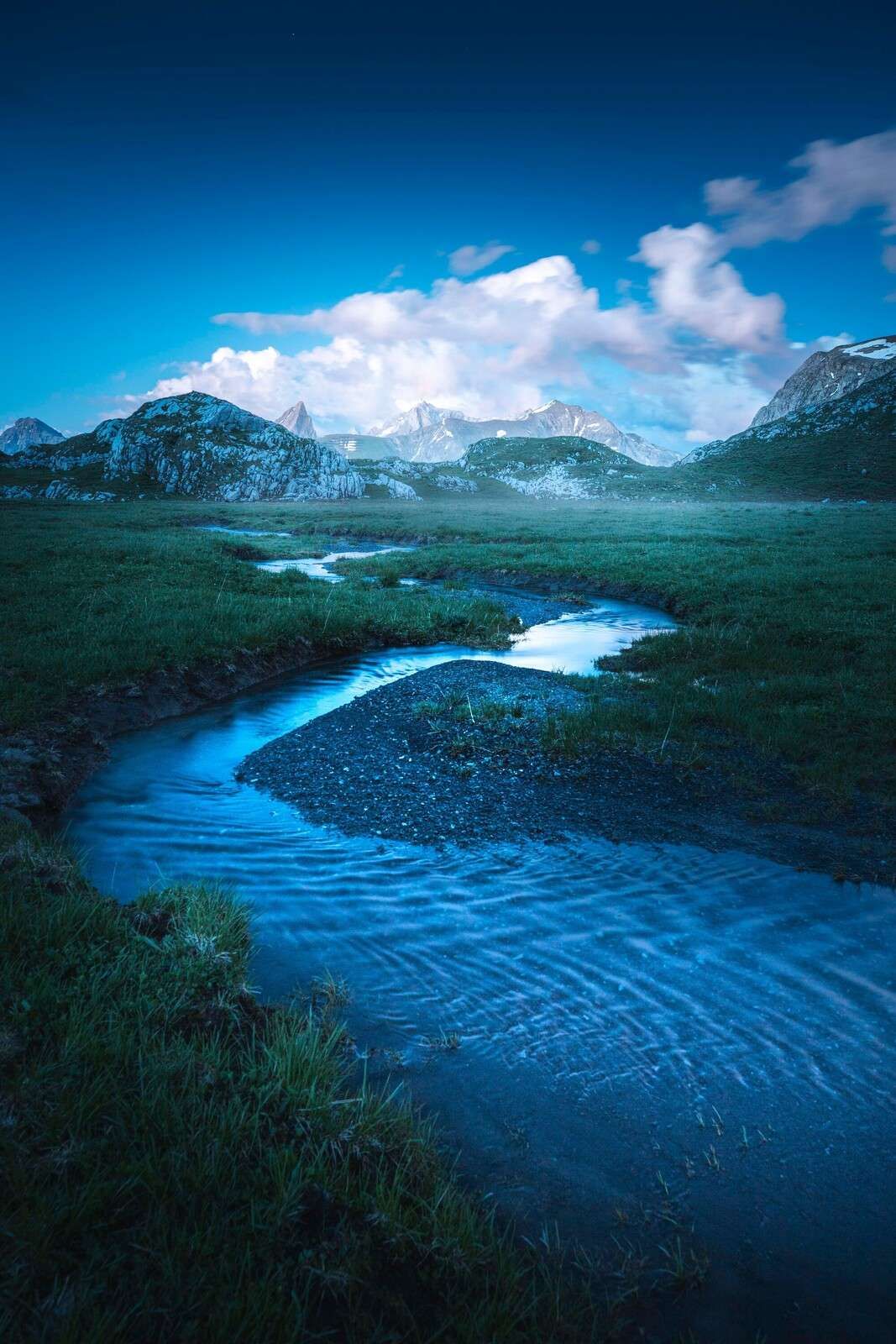 Mountain stream under blue evening sky