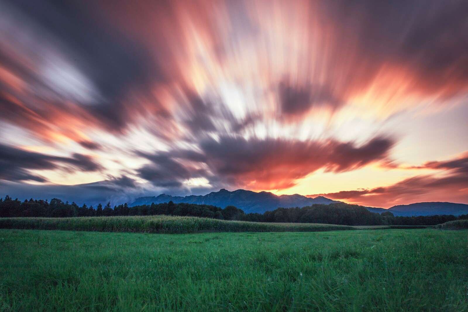 Sunset above green plain