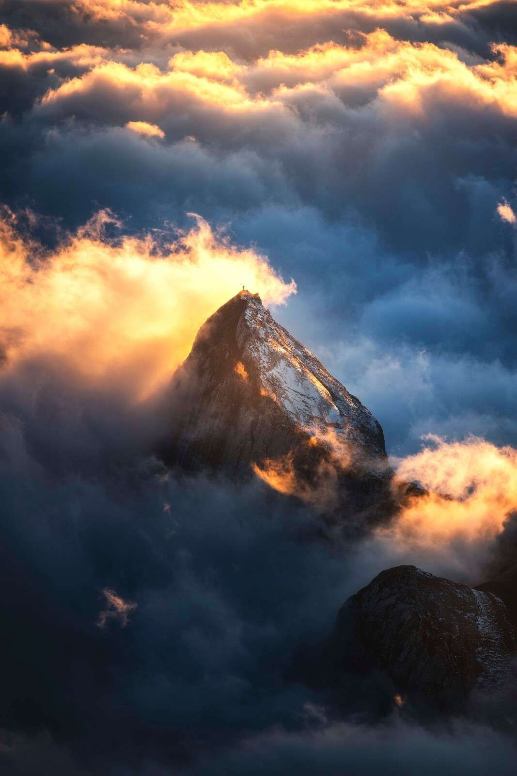 Mountain cross in fiery mist