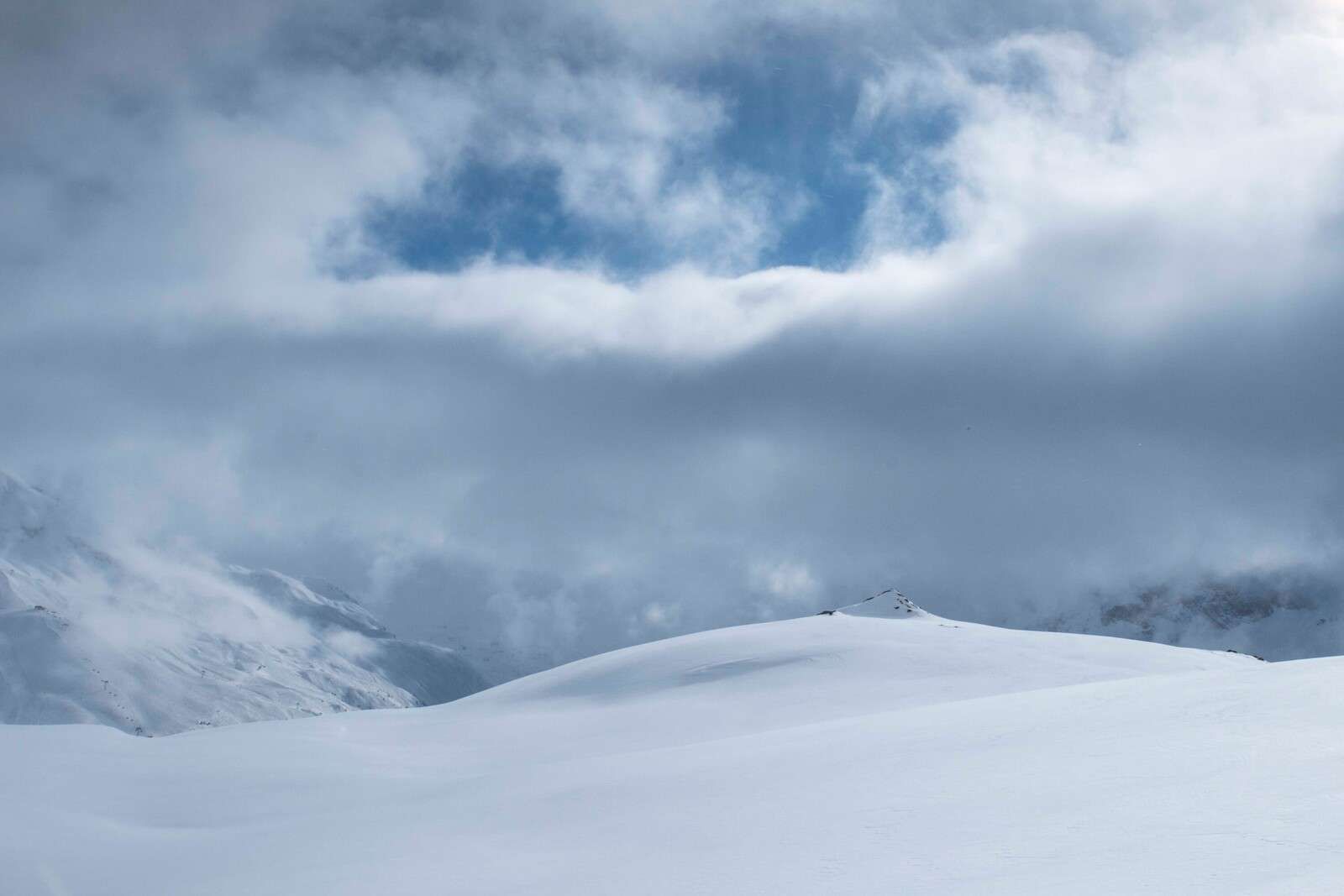 Snow-covered hills under threatening sky