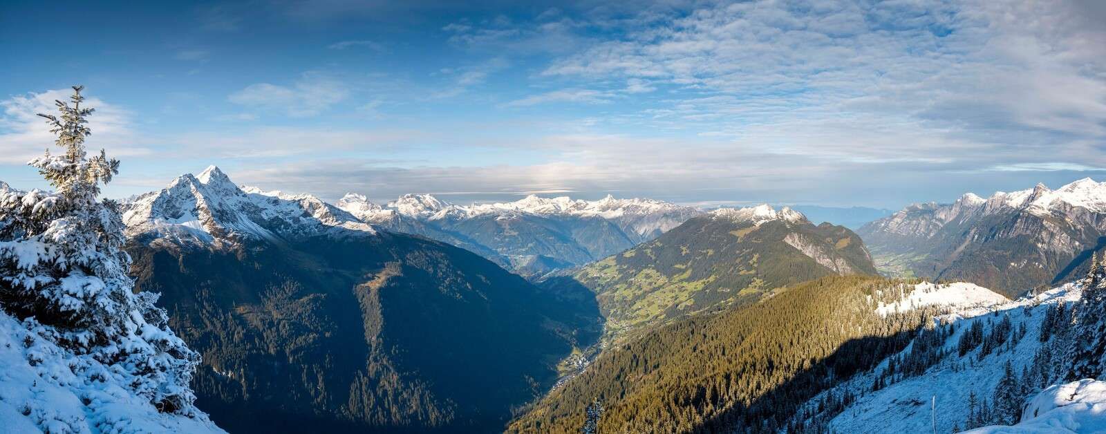 Panorama over snowy alpine valley
