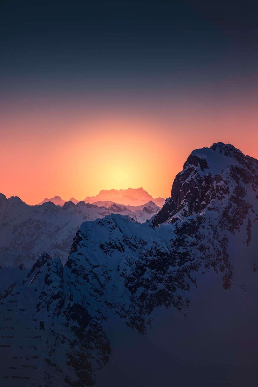Snow-capped mountain peak at fiery sunrise