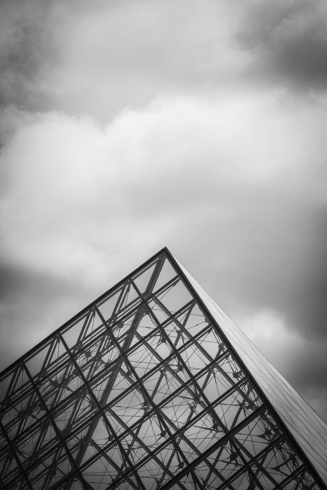 Glass pyramid under cloudy sky