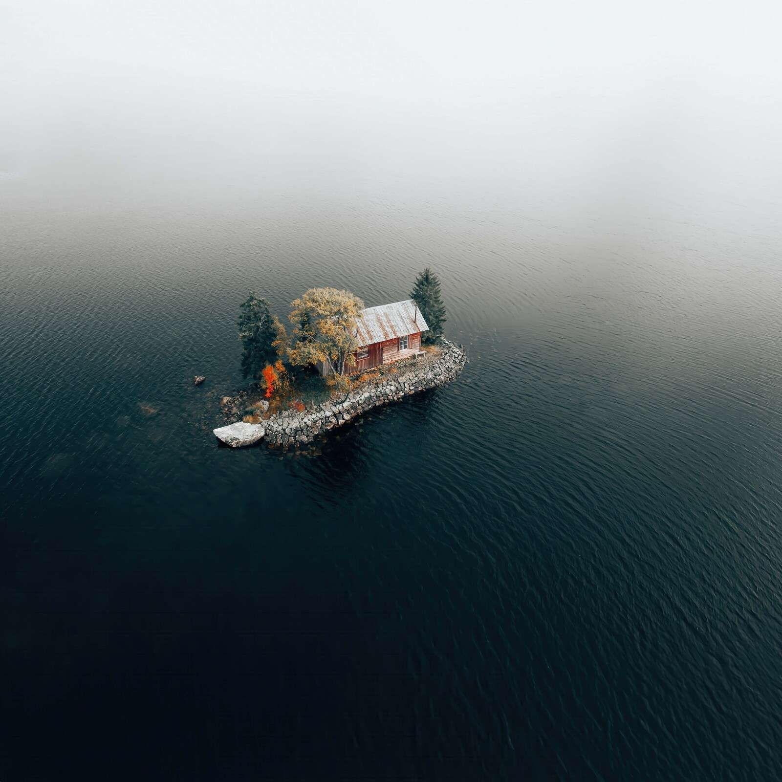 Cabin by a misty island lake