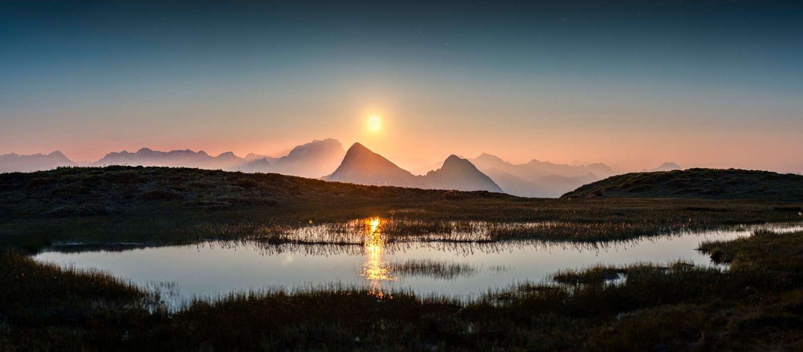 Evening sun above mountain lake