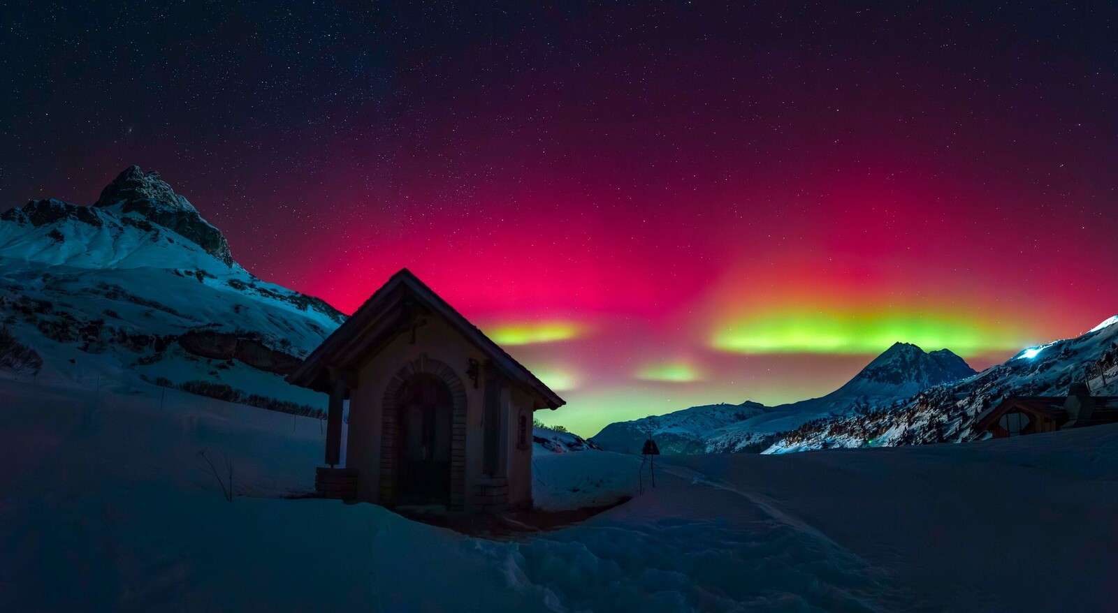 Northern lights above snow-covered mountains