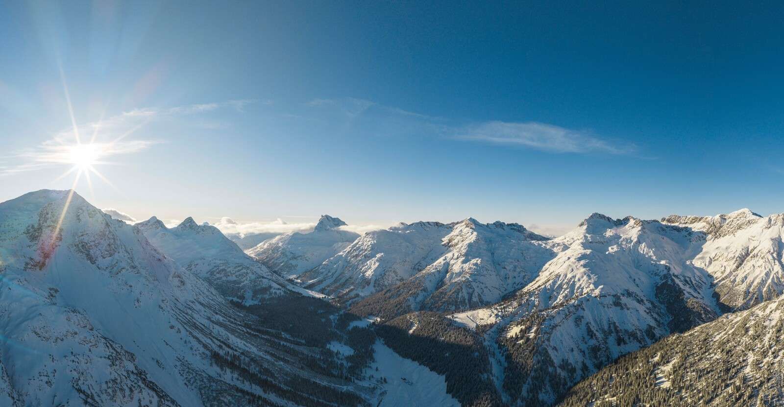 Winter sun above mountain valley