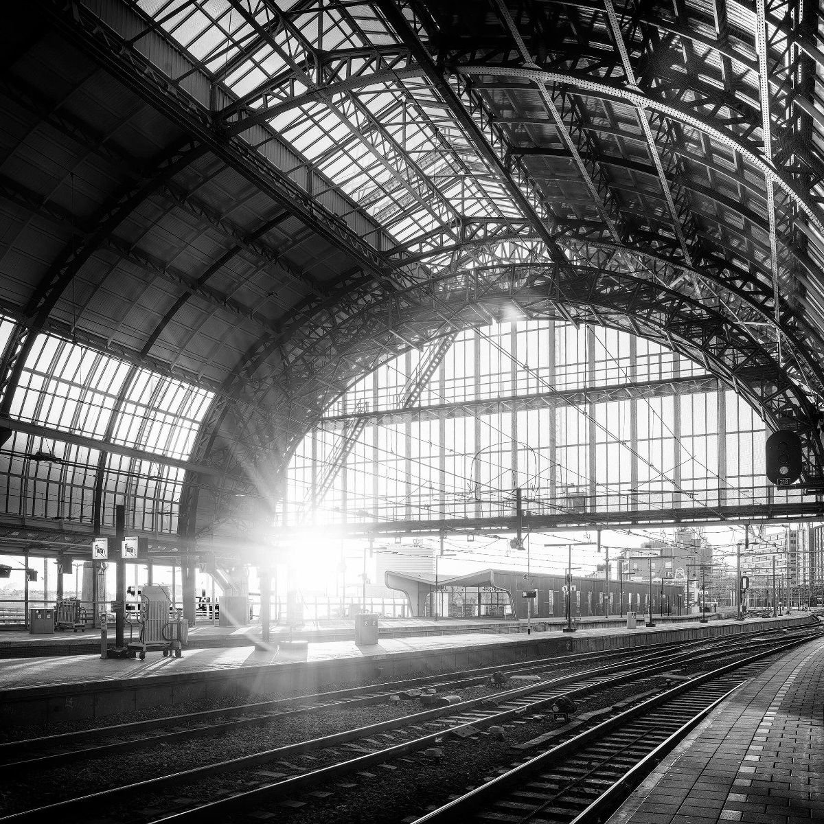 Sonnenaufgang auf einem Bahnhof in Schwarzweiß