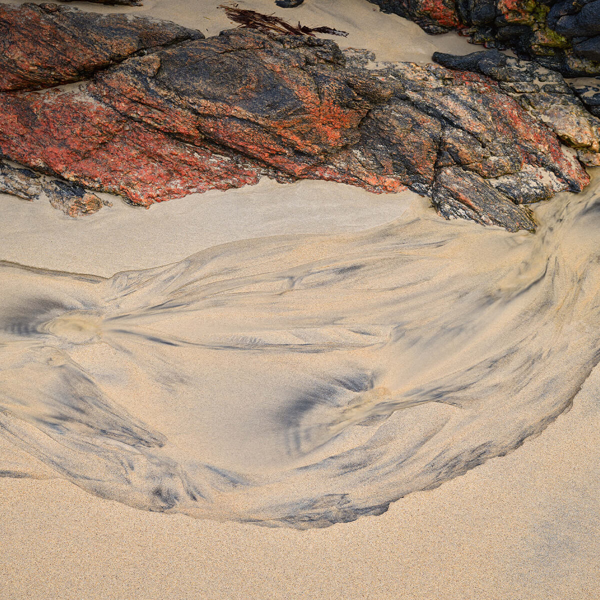 Sandfigur und Felsen