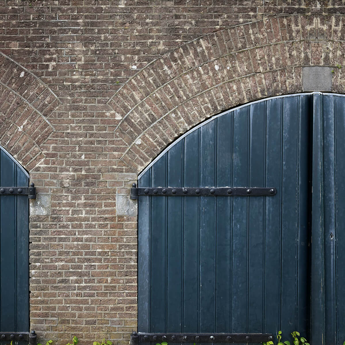 Bakstenen muur met blauwe deuren