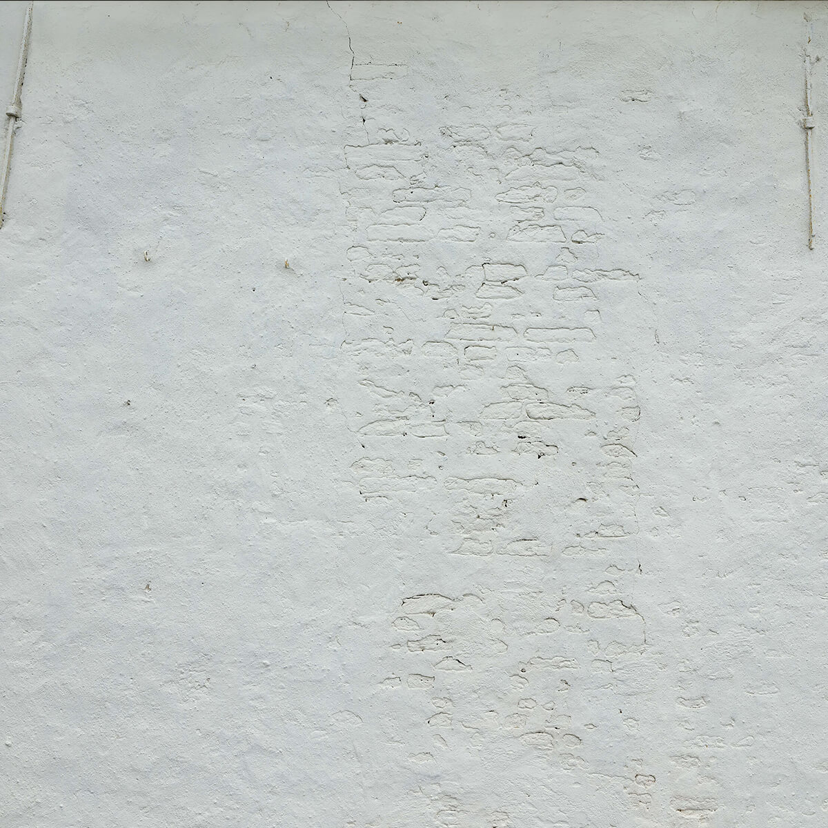 Wall with white stucco and wall anchors