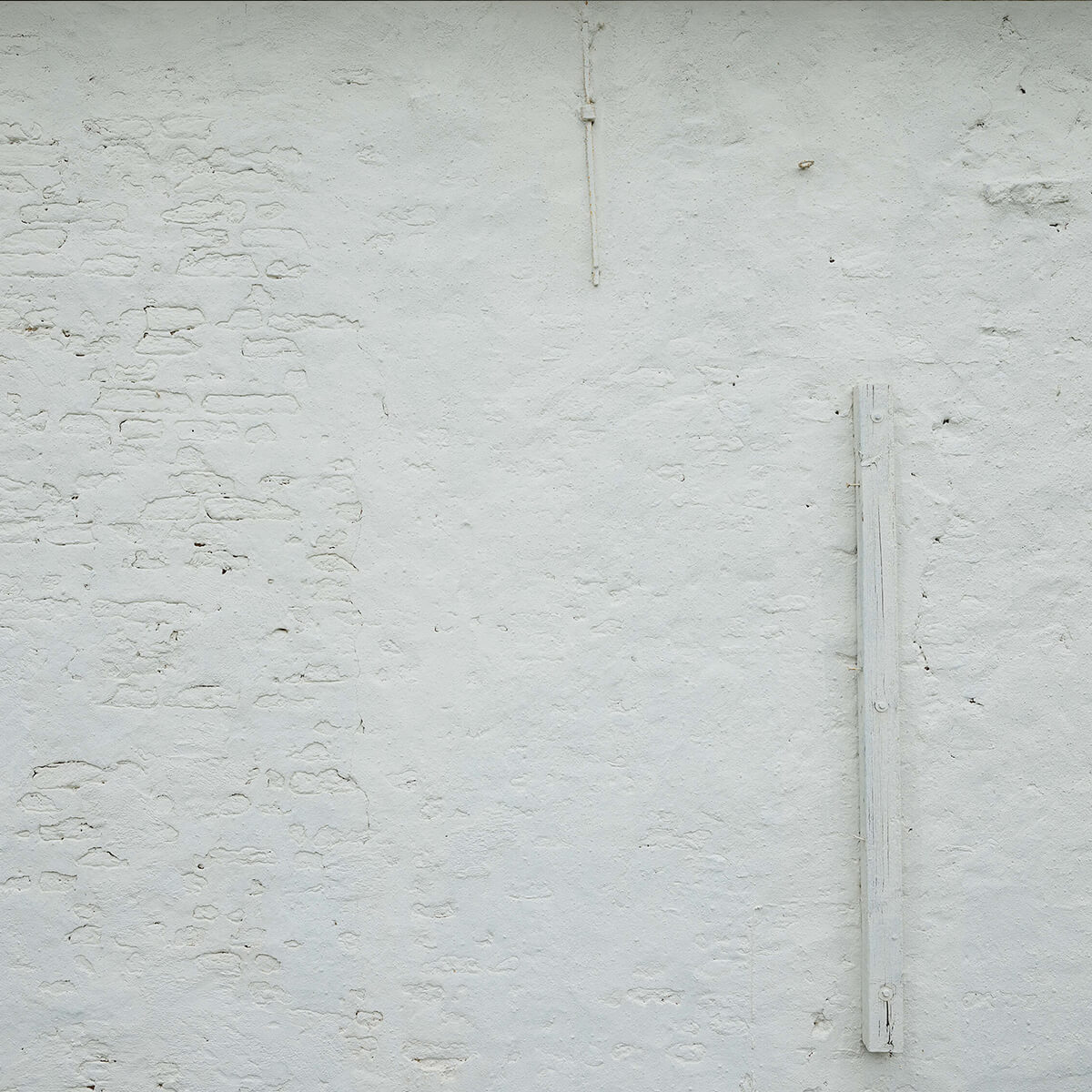 Wall with white stucco and beam